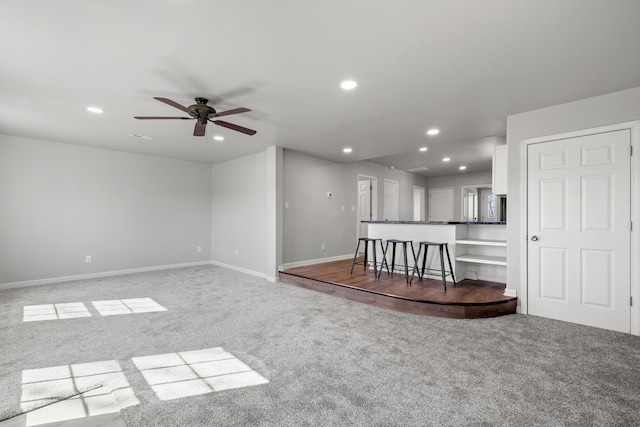 unfurnished living room with carpet, baseboards, and recessed lighting