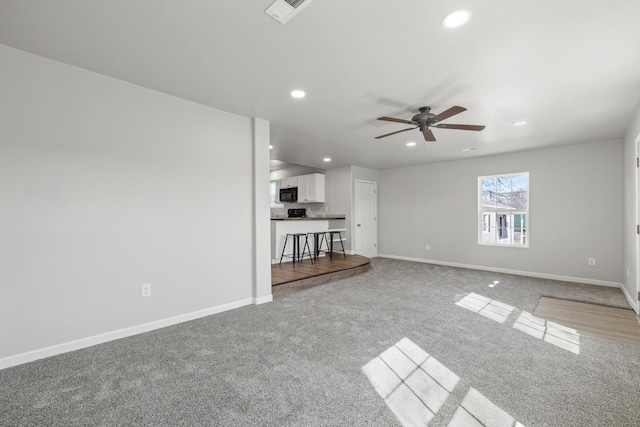 unfurnished living room featuring baseboards, visible vents, and recessed lighting