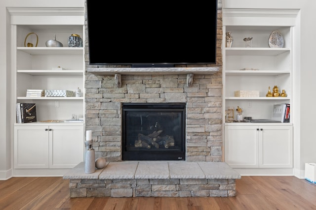 room details with a fireplace, wood finished floors, and built in features