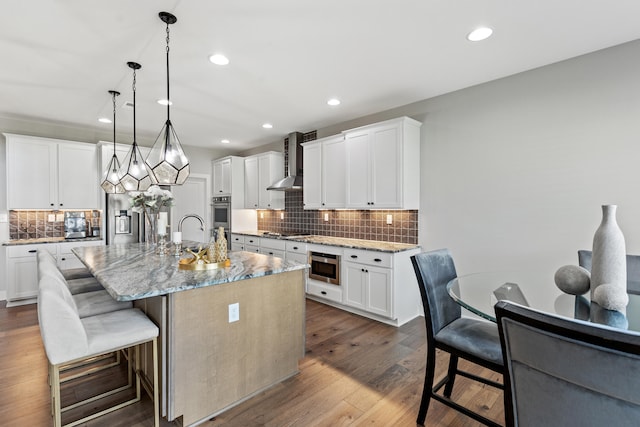 kitchen with a kitchen island with sink and white cabinetry