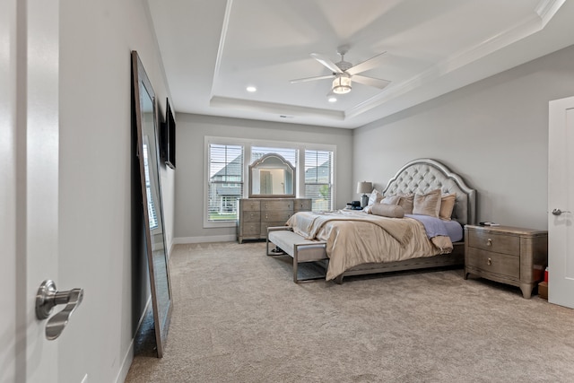 bedroom with a tray ceiling, crown molding, light colored carpet, a ceiling fan, and baseboards