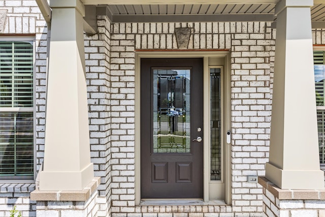 doorway to property featuring brick siding