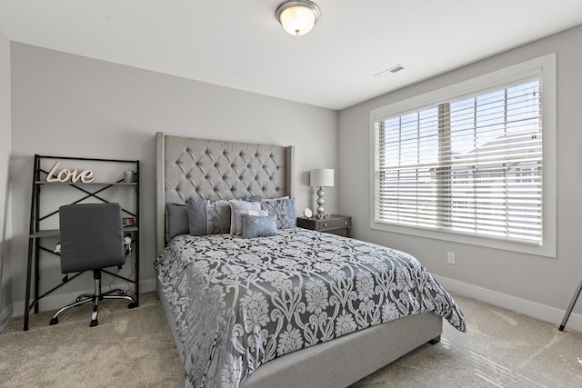 bedroom with light carpet, visible vents, and baseboards