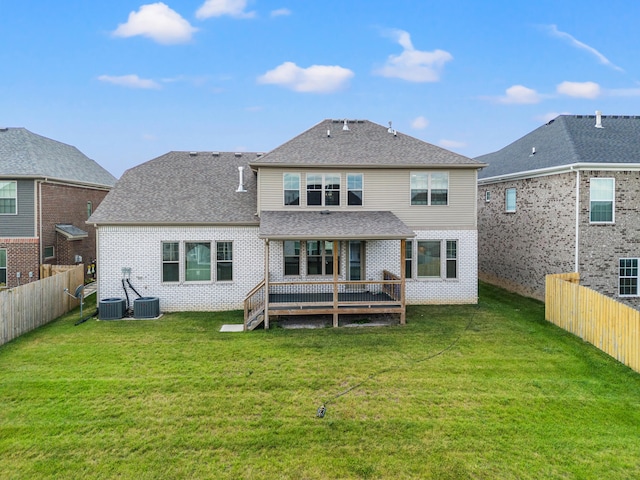 rear view of property with brick siding, a lawn, and a fenced backyard