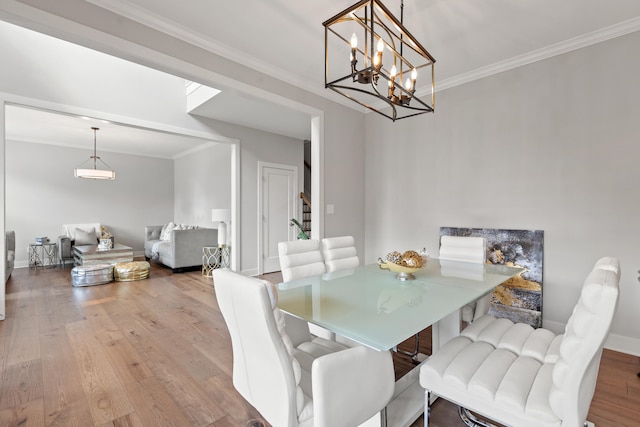 dining room with ornamental molding, baseboards, and wood finished floors