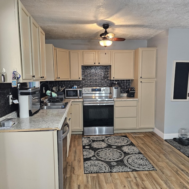 kitchen with tasteful backsplash, stainless steel appliances, light countertops, and wood finished floors