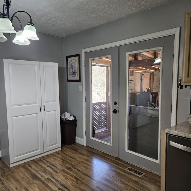 doorway to outside featuring a textured ceiling, visible vents, dark wood-type flooring, and french doors