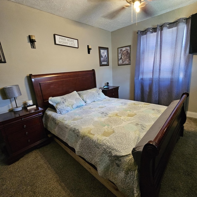 bedroom featuring a textured ceiling, dark carpet, and a ceiling fan