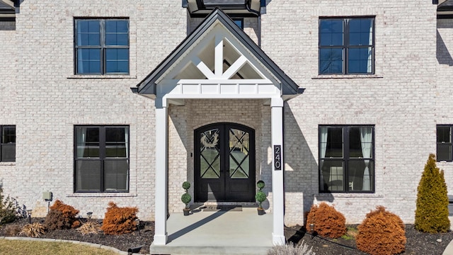 view of exterior entry with french doors and brick siding