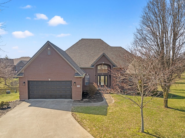 traditional-style house with a front lawn, roof with shingles, concrete driveway, an attached garage, and brick siding