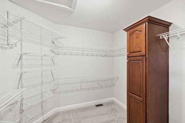 spacious closet with visible vents and light colored carpet