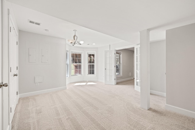 spare room featuring visible vents, french doors, baseboards, light colored carpet, and a chandelier