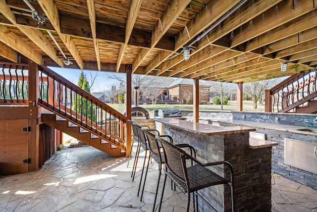 view of patio with stairs and outdoor dry bar