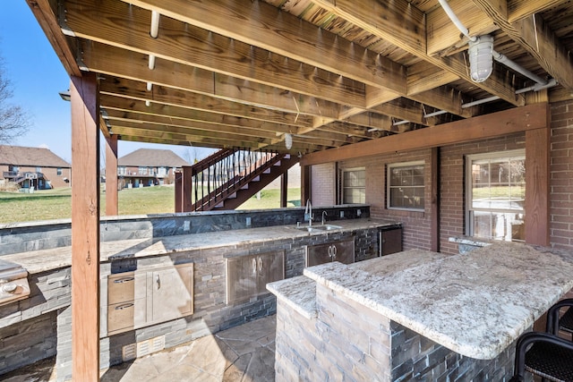 view of patio / terrace featuring area for grilling, stairs, outdoor wet bar, and a sink