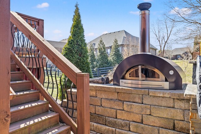 exterior space with stairs, a wood stove, and fence