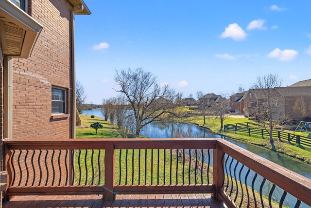 wooden deck featuring a water view and a residential view