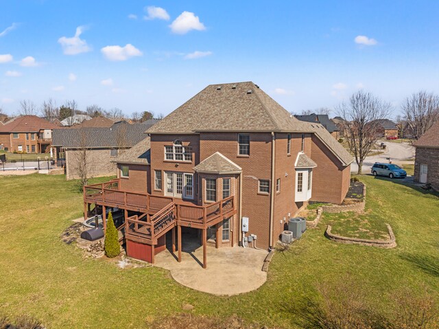 rear view of property featuring cooling unit, a wooden deck, brick siding, a patio area, and a lawn