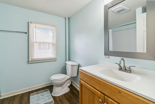 bathroom featuring toilet, wood finished floors, visible vents, vanity, and baseboards