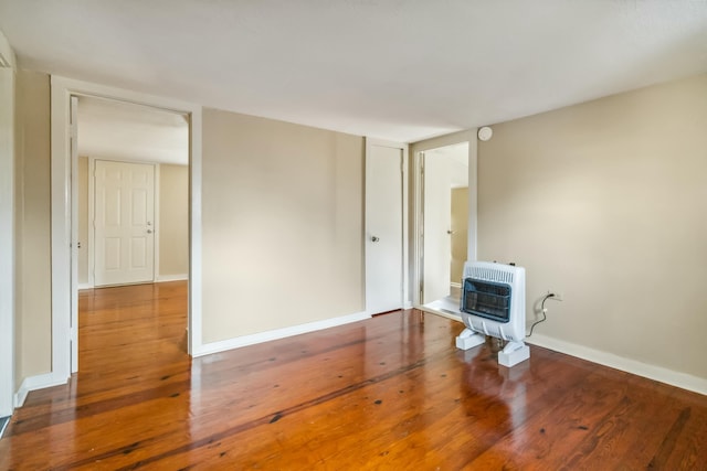 417 Harmon Hts, Stanford, KY 40484 - empty room with wood finished floors, baseboards, a wood stove, and heating unit
