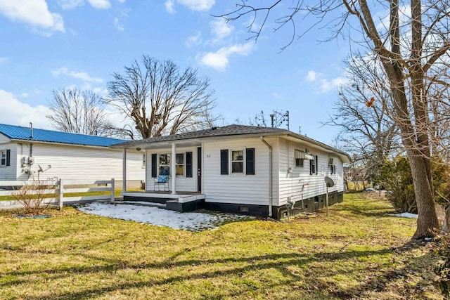 back of house with covered porch and a lawn