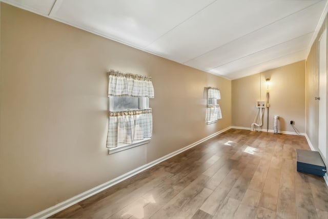 spare room featuring baseboards and wood finished floors