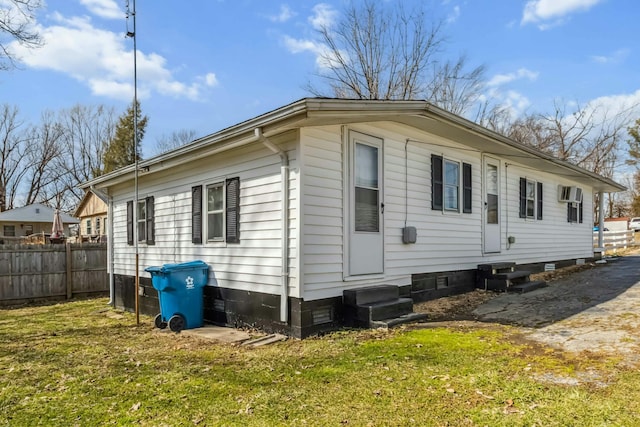 exterior space featuring a yard, entry steps, crawl space, fence, and a wall mounted air conditioner