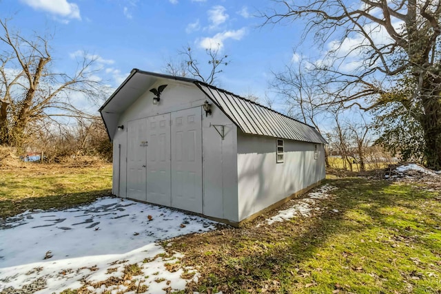 snow covered structure featuring an outbuilding