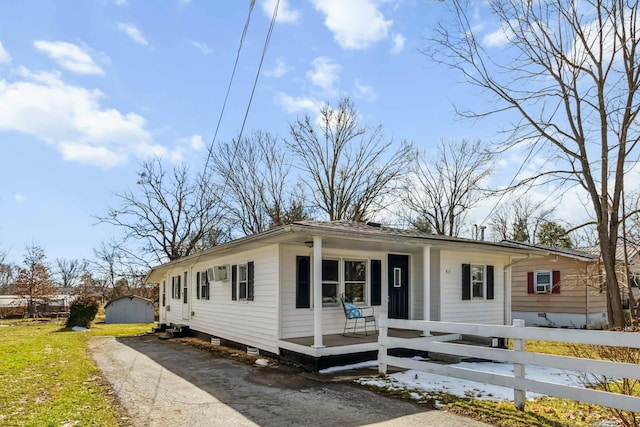 view of front facade with driveway, covered porch, and fence