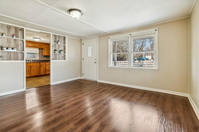 interior space featuring baseboards and dark wood finished floors