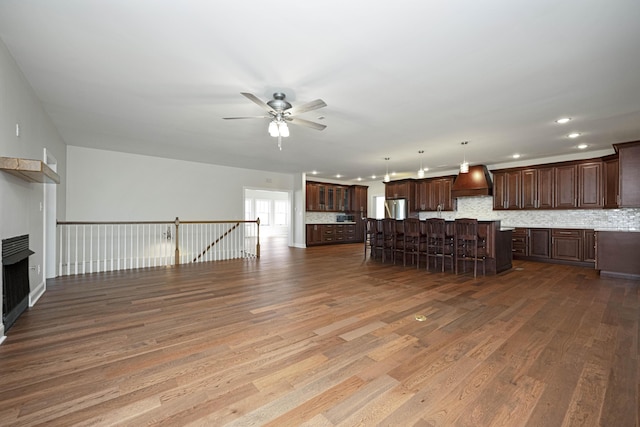 unfurnished living room featuring a fireplace, a ceiling fan, wood finished floors, and recessed lighting