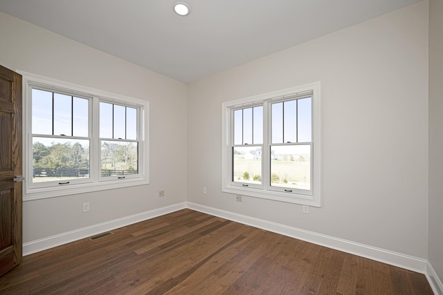 spare room featuring recessed lighting, visible vents, dark wood finished floors, and baseboards