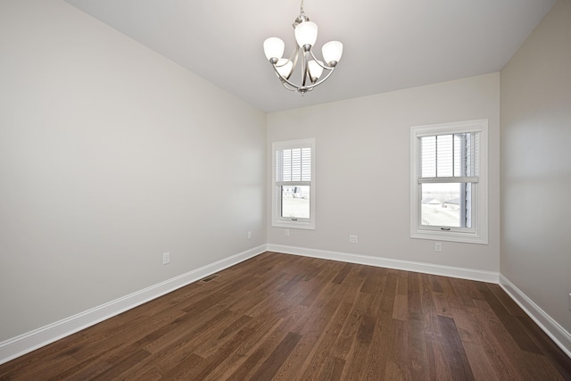 unfurnished room featuring a chandelier, visible vents, dark wood finished floors, and baseboards