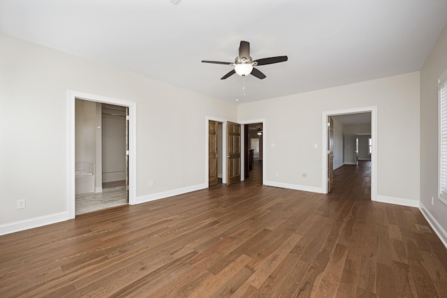 interior space with dark wood-style floors, baseboards, and a ceiling fan