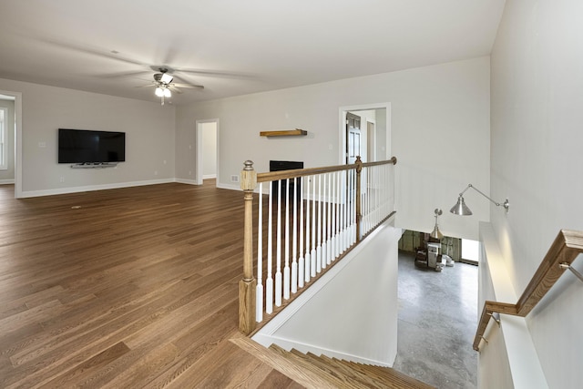 interior space with ceiling fan, baseboards, and wood finished floors