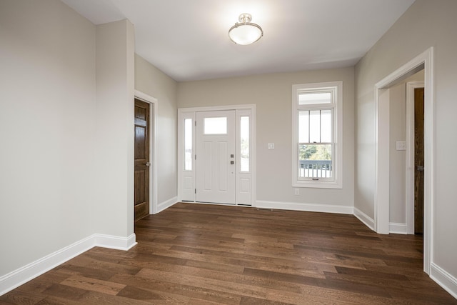 foyer entrance with dark wood-style floors and baseboards