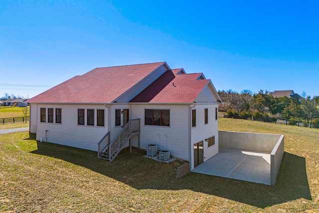 exterior space featuring central air condition unit, a lawn, a patio area, fence, and driveway