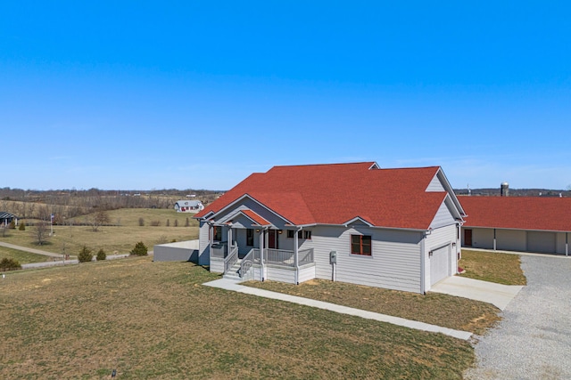 view of front of home featuring a garage, covered porch, driveway, and a front lawn