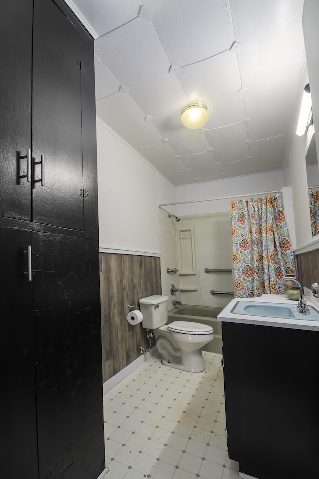 full bath with tile patterned floors, shower / bath combination with curtain, wood walls, toilet, and vanity