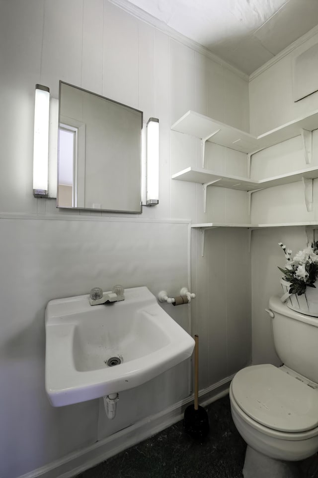 half bathroom featuring toilet and a sink