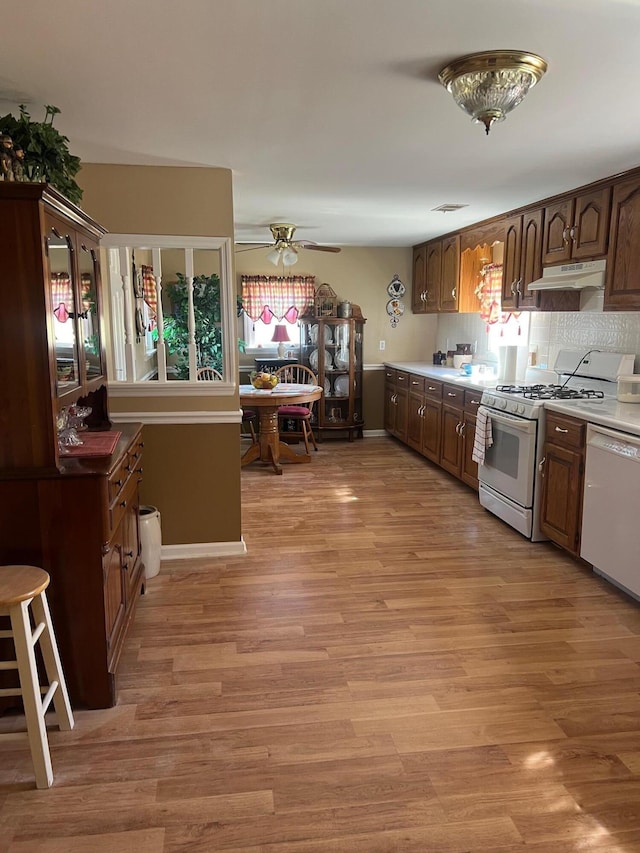 kitchen featuring ceiling fan, under cabinet range hood, white appliances, visible vents, and light wood finished floors