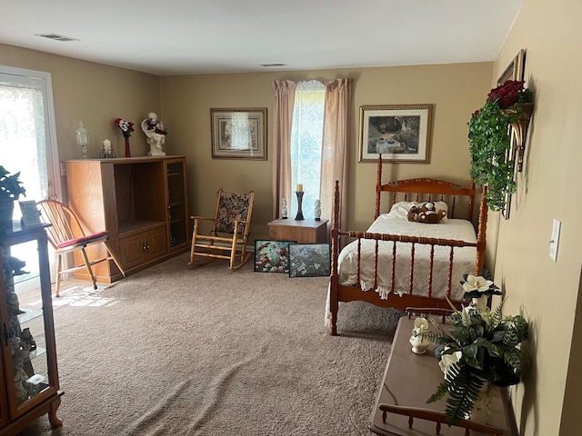 carpeted bedroom featuring visible vents