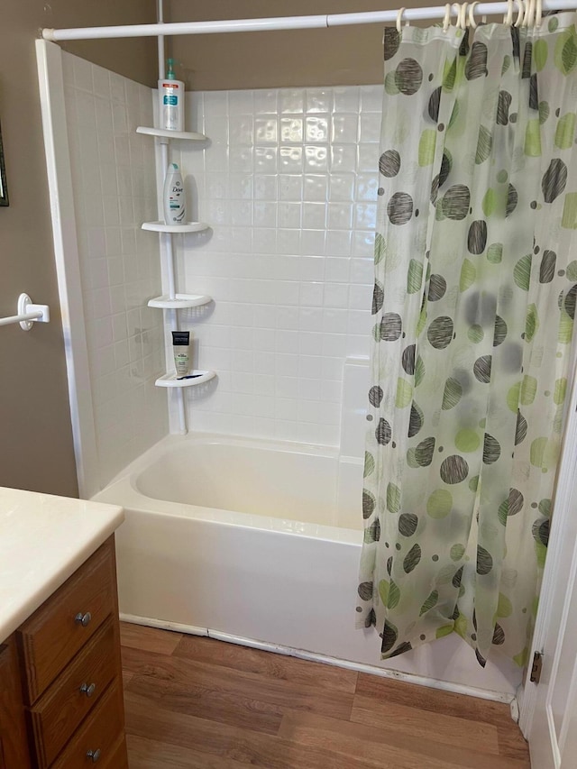 bathroom with shower / bathtub combination with curtain, wood finished floors, and vanity