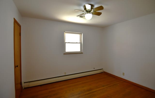 unfurnished room with baseboards, ceiling fan, baseboard heating, and wood finished floors