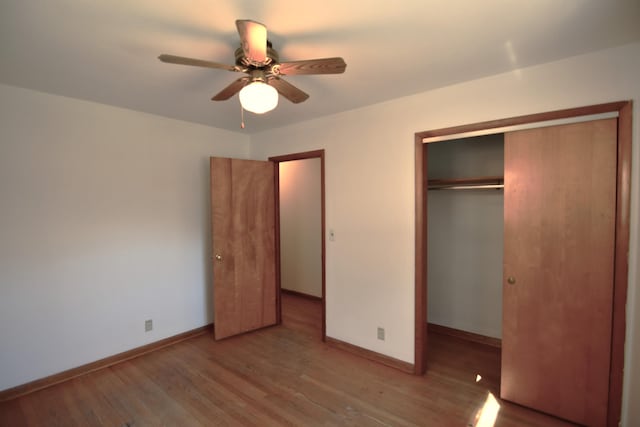 unfurnished bedroom featuring ceiling fan, a closet, baseboards, and wood finished floors