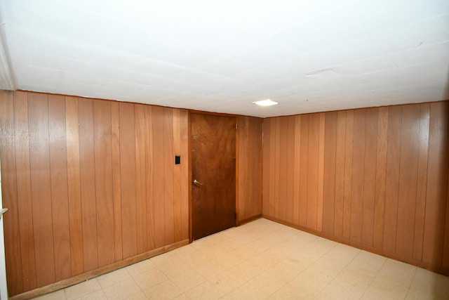 spare room featuring wooden walls and light floors