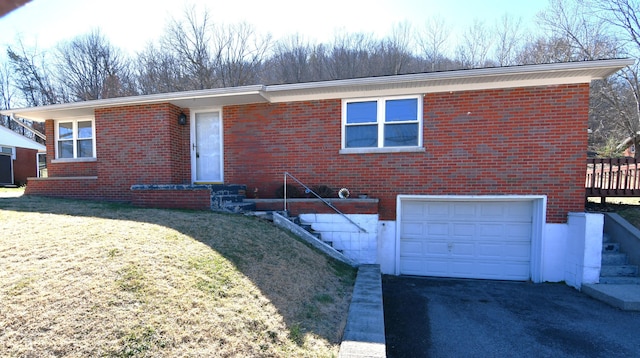 ranch-style home featuring a garage, a front yard, brick siding, and aphalt driveway