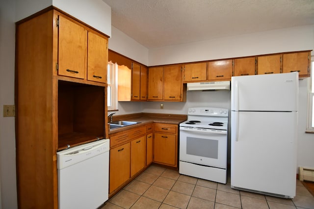 kitchen with white appliances, brown cabinets, and under cabinet range hood