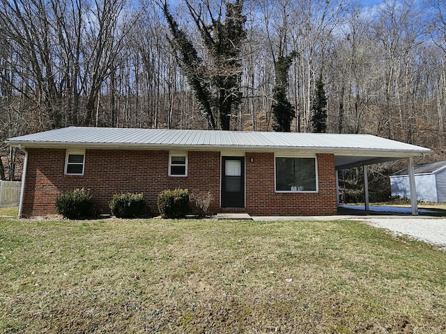 single story home featuring metal roof, brick siding, driveway, a carport, and a front yard