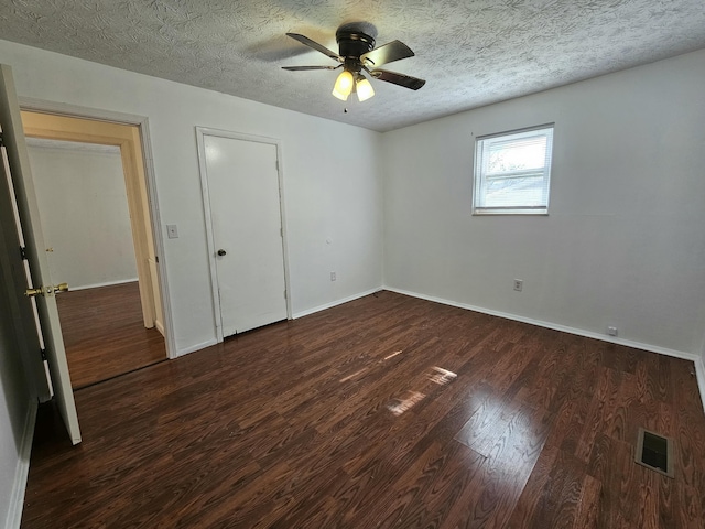 unfurnished bedroom with baseboards, visible vents, a ceiling fan, wood finished floors, and a textured ceiling