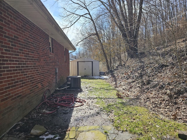 view of yard featuring an outdoor structure, central AC unit, and a shed